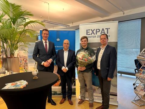  Op de foto zie je IND Directeur Dienstverlenen Roelof Triemstra en de wethouders, die samen de eerste klant ontvingen: Levi uit Canada. Hij heeft bloemen gekregen.